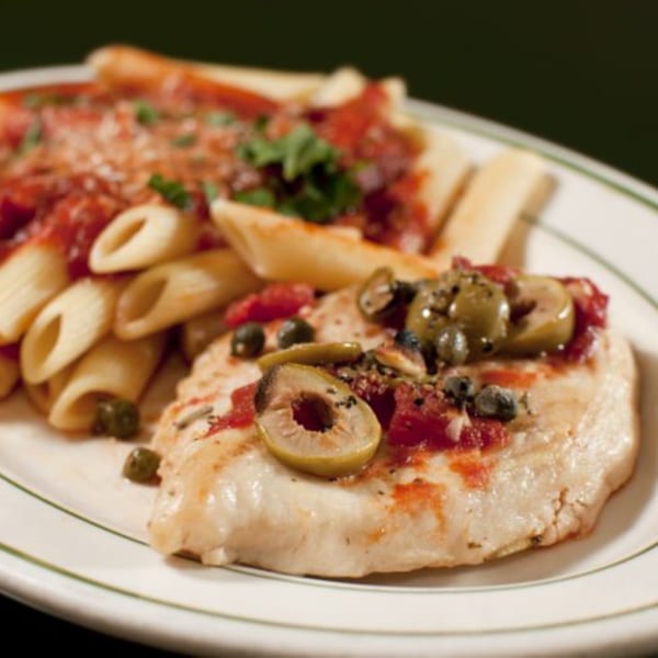 Chicken breast topped with olives, capers, and tomato sauce, served with penne pasta.
