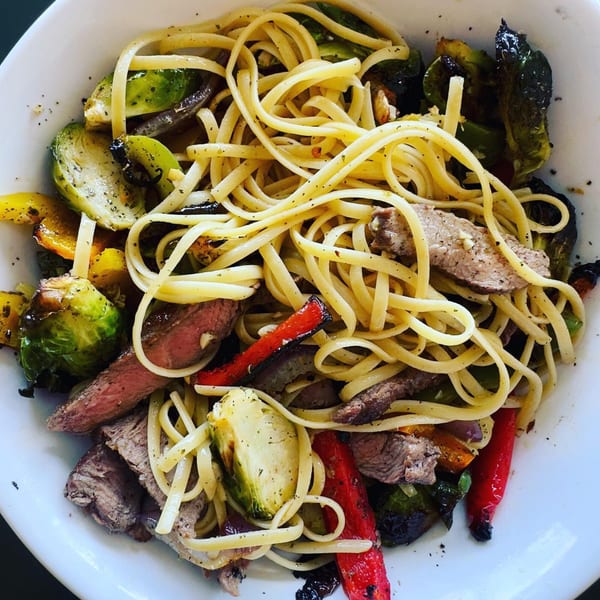 Tony & Alba's linguine pasta with sliced steak, roasted brussels sprouts, and red bell peppers.